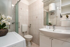 A modern bathroom with a toilet, sink, and shower. - Villa Sali (Sali)