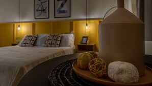 Ein modernes Schlafzimmer mit Bett, Nachttischen und Wandbildern.