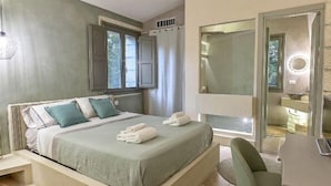 A bedroom with a bed, a bedside table, a chair, a mirror, and a window with curtains. - Townhome (Castrignano De' Greci)