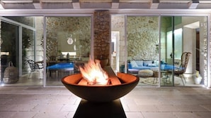 A modern outdoor seating area with a fire feature in the center. - Townhome (Castrignano De' Greci)