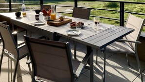 A dining table set outdoors with a scenic view, including a bottle of orange juice, croissants, and a glass of coffee. - Appartement T3 de Standing - 2 Chambres 4/6 Personnes Porto Vecchio (Porto-Vecchio)