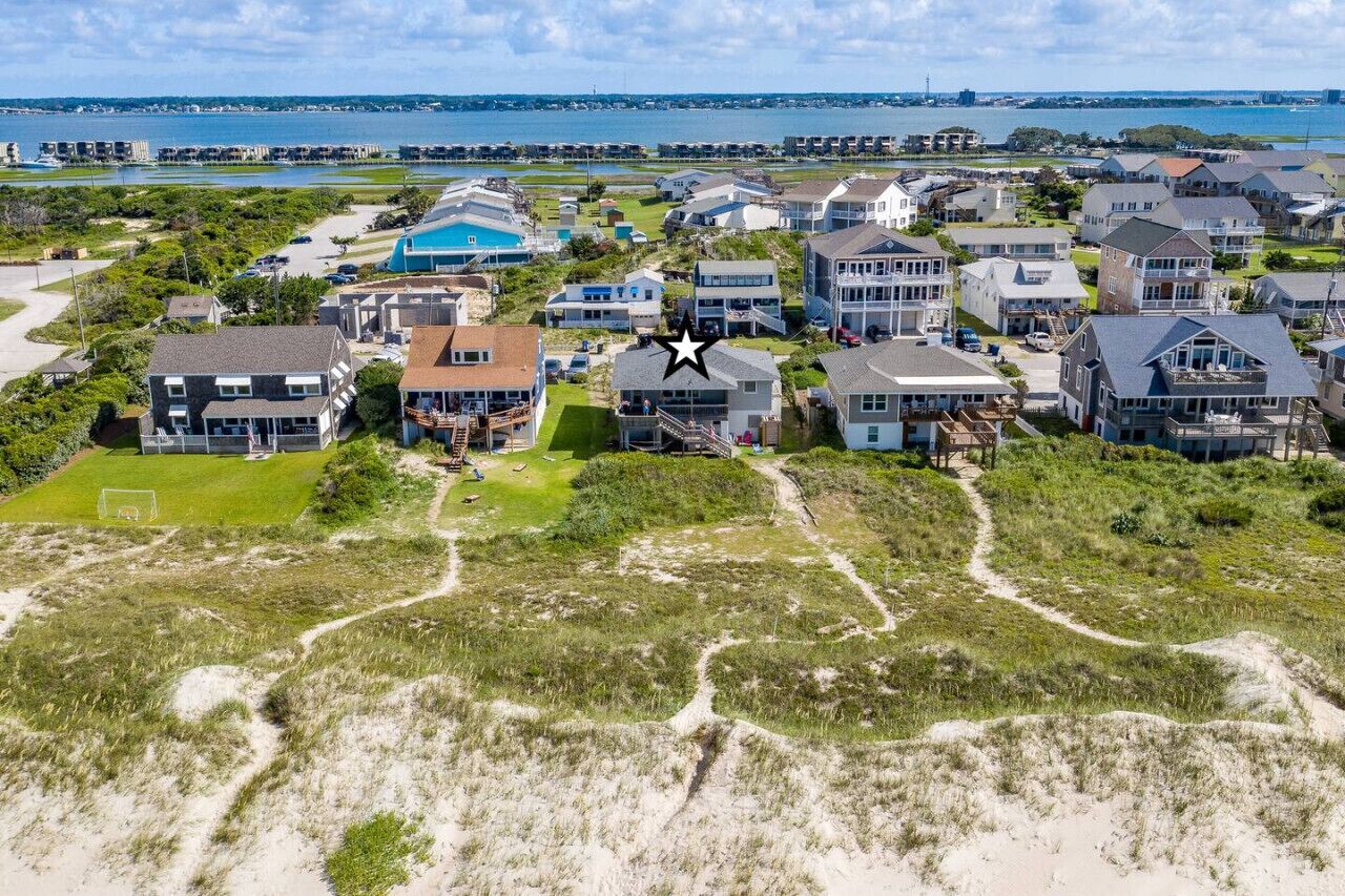 A coastal residential area with houses, a beach, and a view of the sea.