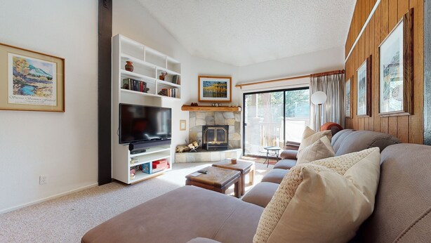 A living room with a fireplace, a television, and a sofa. - Summit 293 Bright, Spacious with Under Ground Parking, Walk to Eagle Lodge by RedAwning (Mammoth Lakes)