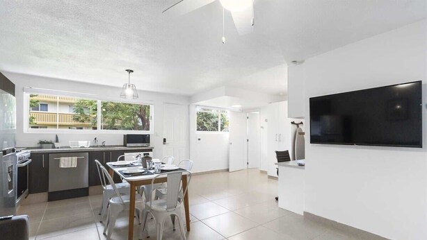 Una cocina moderna con comedor, ventanas amplias y un televisor de pantalla plana.