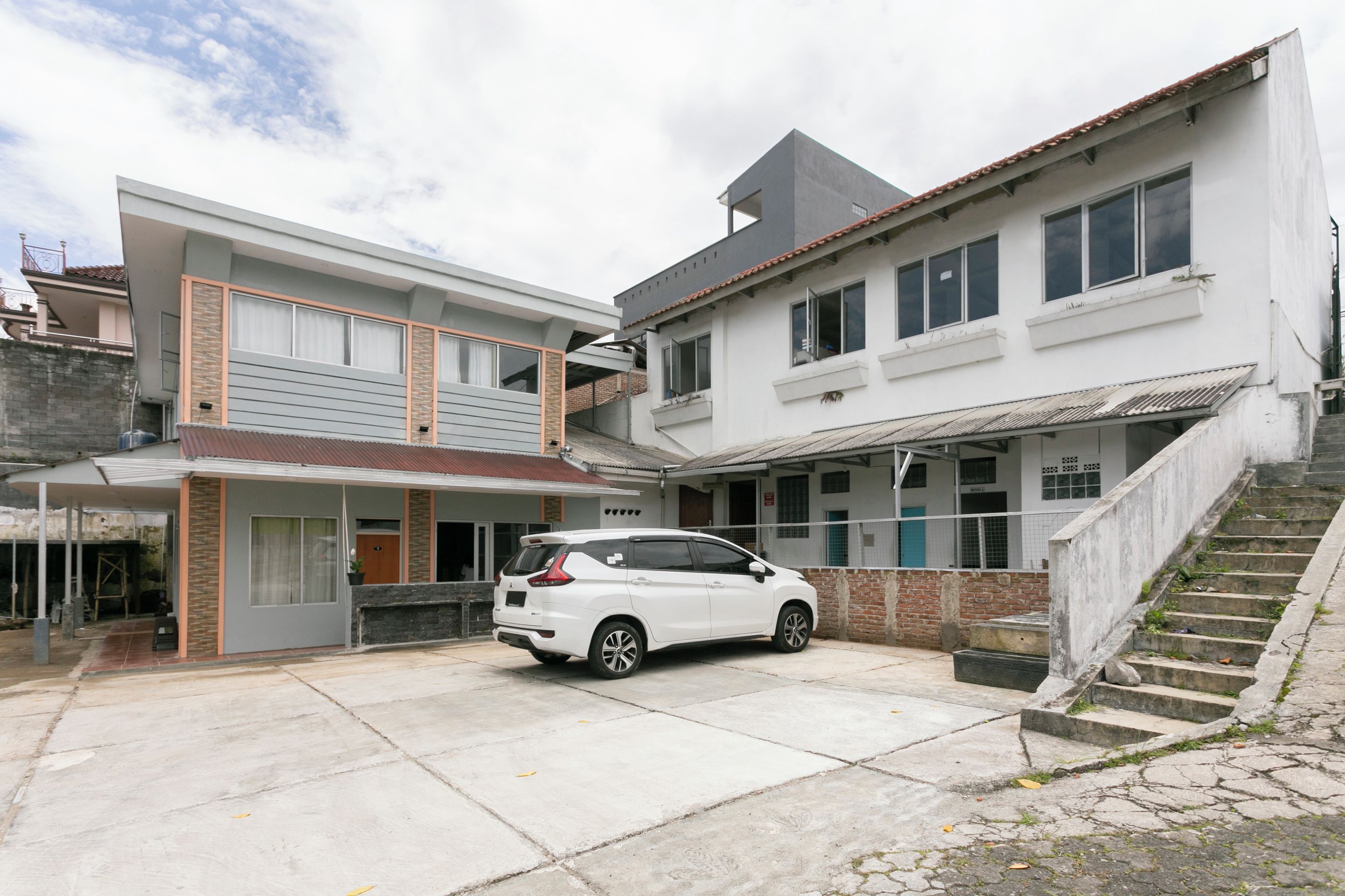 A modern two-story house with a car parked in the driveway.