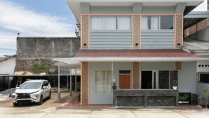 A two-story house with a balcony, a garage, and a driveway. - Oyo 3130 Valley (Lembang)