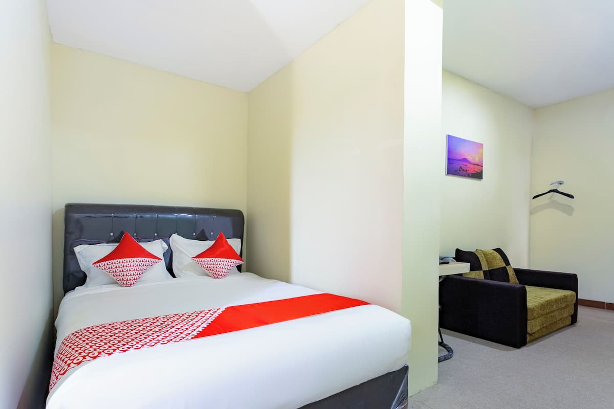 Una habitación de hotel con una cama, un sofá y una pequeña mesa.