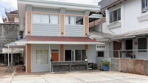 A two-story residential building with a covered entrance, a balcony, and a small garden area. - Oyo 3130 Valley (Lembang)