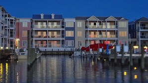 A waterfront hotel with multiple-story buildings, balconies, and a dock with boats. - Bayside & Beyond- 1st Floor Waterfront Condo with Pool, Gym & Boat Slip (Chincoteague)