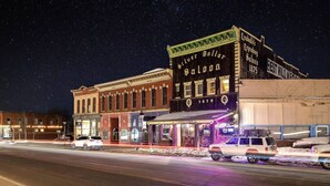 A historic downtown street with buildings, including a saloon with a sign reading "Silver Dollar Saloon 1879".