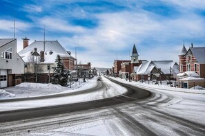 Eine verschneite Straße mit historischen Gebäuden und einem Kirchturm.