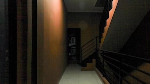 A narrow, dimly lit hallway with a staircase on the right. - OYO 3456 Citara Jaya Guesthouse (Bekasi)