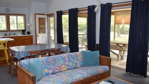 A cozy room with a sofa, a dining table, and a kitchen area.