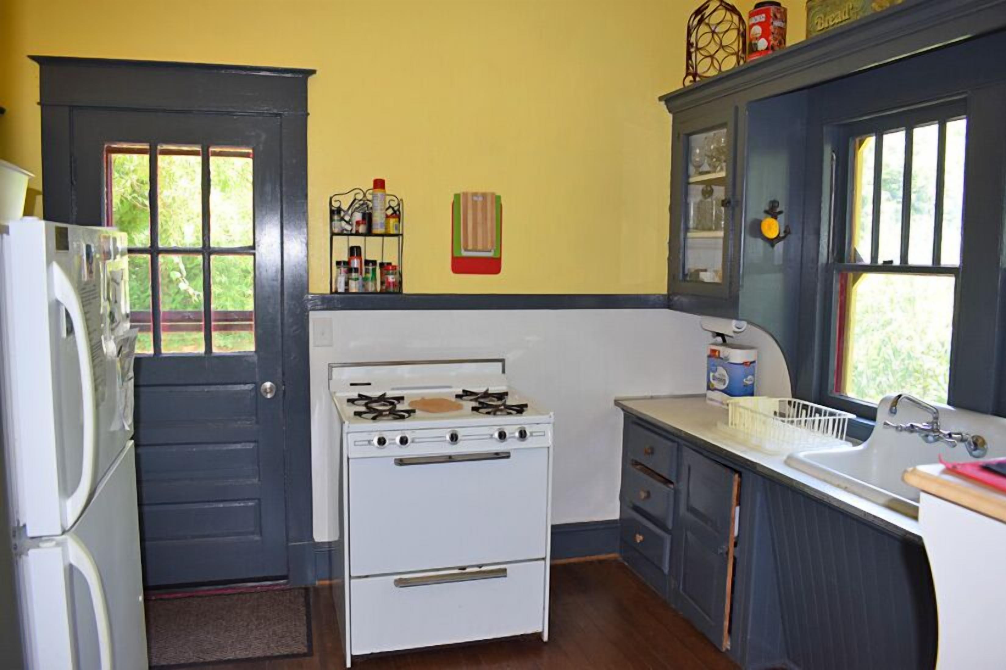 Una cocina compacta con estufa blanca, lavamanos y refrigerador.