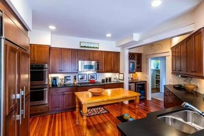 Enjoy cooking in this well-equipped kitchen with a central island, sink, and refrigerator.