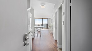 A hallway with a wooden floor, white walls, and a door with a silver handle. - Carolina Reef 804 - Ocean Front 1 Bedroom Unit - Great Views (North Myrtle Beach)