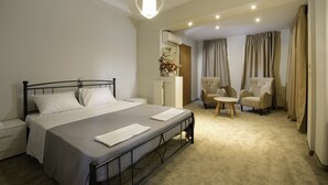Une chambre d’hôtel avec un lit, un bureau, deux chaises et une petite table.