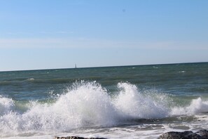 A coastal scene with waves crashing onto rocks.