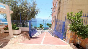 Un sendero pavimentado que lleva a una puerta con vista al mar.