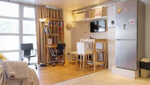 A compact living space with a kitchenette, a dining area, and a workspace. - Fantastically Located 2BDR Studio in Kennington (London)