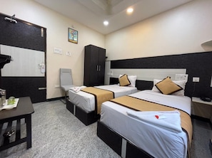 A hotel room with two beds, a desk, a wardrobe, and a painting on the wall. - Hotel Rathnavel Towers (Chennai)