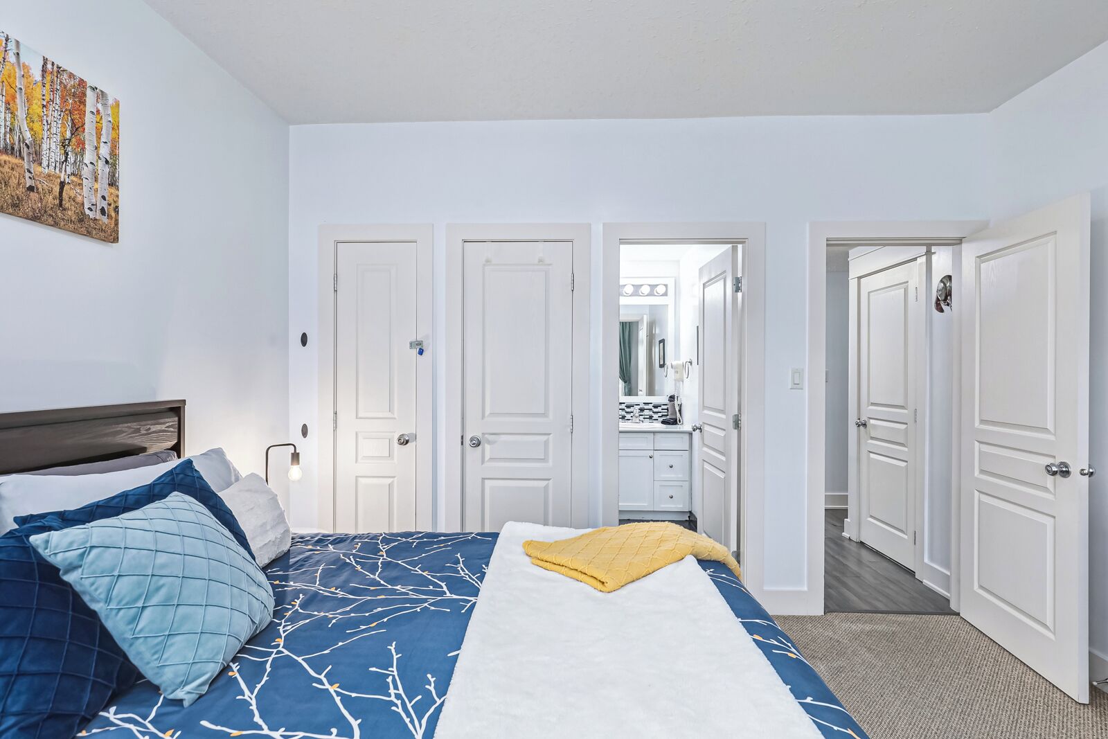A bedroom with a bed, a bedside table, a nightstand, and a wardrobe.
