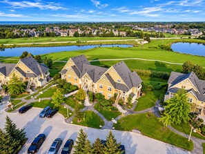 Un quartier résidentiel comprenant des maisons, un terrain de golf et une étendue d’eau.