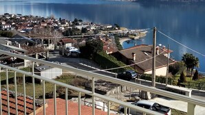 Un balcón con vistas a un lago, montañas y un pueblo.