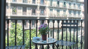 A balcony with a potted plant, a table, and a chair. - New apartment in the Center, Eixample Best Area! 2 minutes to Passeig de Gracia  (Barcelona)