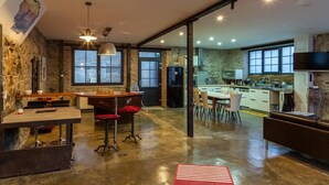 Et moderne køkken med spiseplads, store vinduer og en stenvæg.