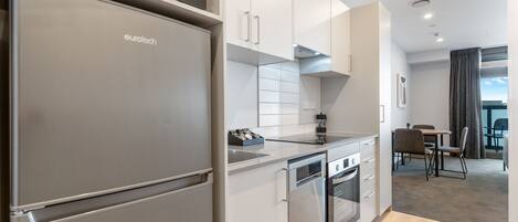 A modern kitchen with a built-in refrigerator, oven, and dishwasher.