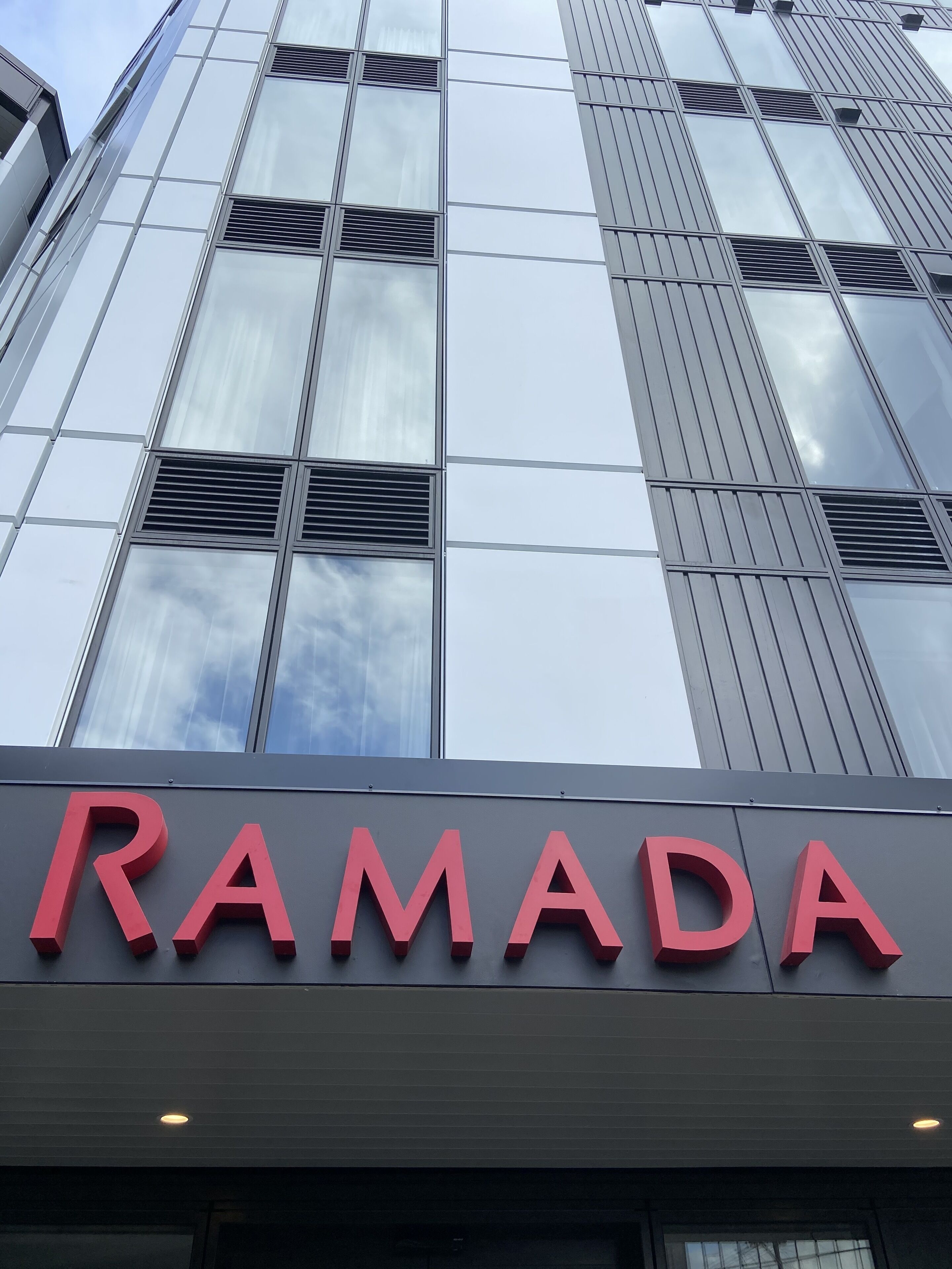 Un edificio moderno con un grande cartello che riporta la scritta "RAMADA".