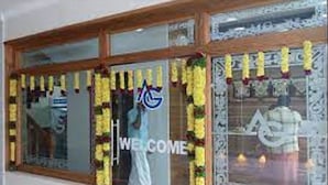 A hotel entrance with a welcome sign, a glass door, and a decorative garland. - Anandha Grand (Tiruchendur)