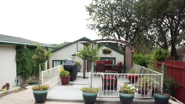 A patio area with outdoor seating, potted plants, and a covered grill. - Cozy 1 Bedrm/1 Bth, Walk to Downtown, Pet Friendly, Fenced yard, Covered Patio (Prescott)