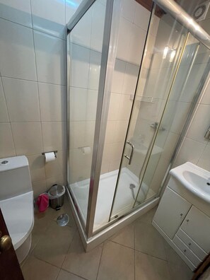 Une salle de bain moderne avec une douche à parois de verre, des toilettes et un lavabo.