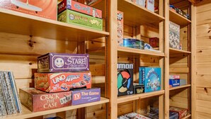 Uno scaffale di legno con diversi giochi da tavolo e riviste.