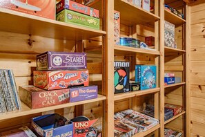A wooden shelf with various board games and magazines.