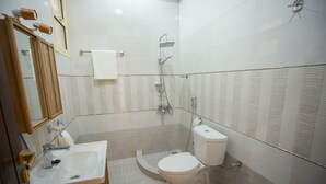 Une salle de bain moderne équipée d’un lavabo, de toilettes et d’une douche.