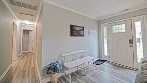 Ein Flur mit einer Bank, einer Tür mit Fenster und einem an der Wand befestigten Schild.