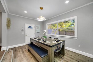 A dining area with a wooden table, bench seating, and a view of trees through a window. - Heated Pool & Spa, Sleeps 8, South Tampa | 5 Min to MacDill AFB (Tampa)