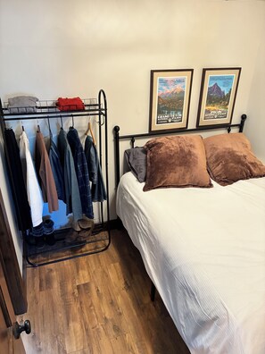 A bedroom with a bed, a clothing rack, and two framed posters on the wall. - Canyons Village 1 BR + Sleeping Loft/Sleeps 4/Free Ski Shuttle (Park City)