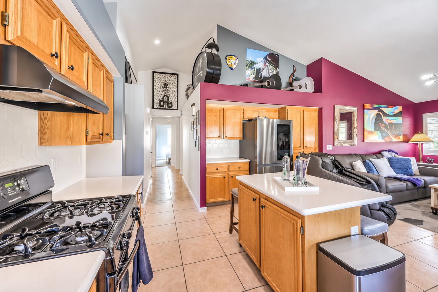 A modern kitchen with a stove, refrigerator, and wooden cabinets.