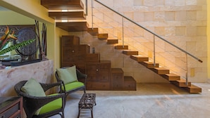 Eine Treppe mit Holzstufen und Metallgeländern, die zu einer höheren Etage führt.