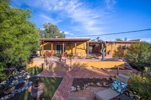 A modern house with a patio, outdoor seating, and a small garden.