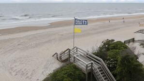 Une plage accessible au public, avec une promenade en bois et une vue sur l’océan.