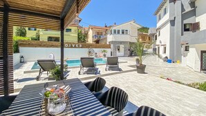 A poolside area with lounge chairs, a table with fruit, and a sign reading "DIVES". - Amazing home in Rukavac (Rukavac)