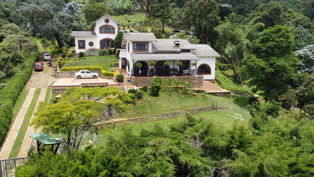 A large, two-story house with a spacious patio and a well-maintained garden.