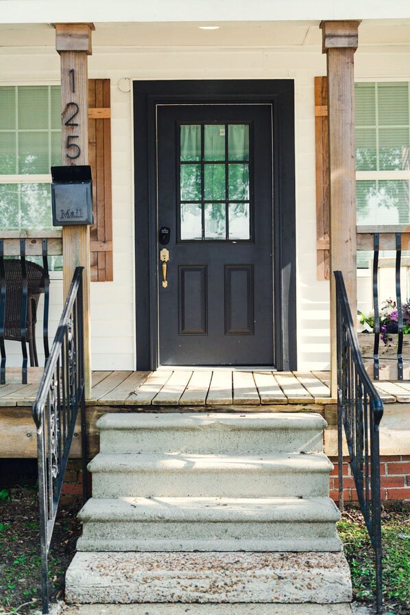 A black front door with a mailbox labeled "Mail" and the number "125" on the left. - Downtown Cottage Getaway (Lake Charles)