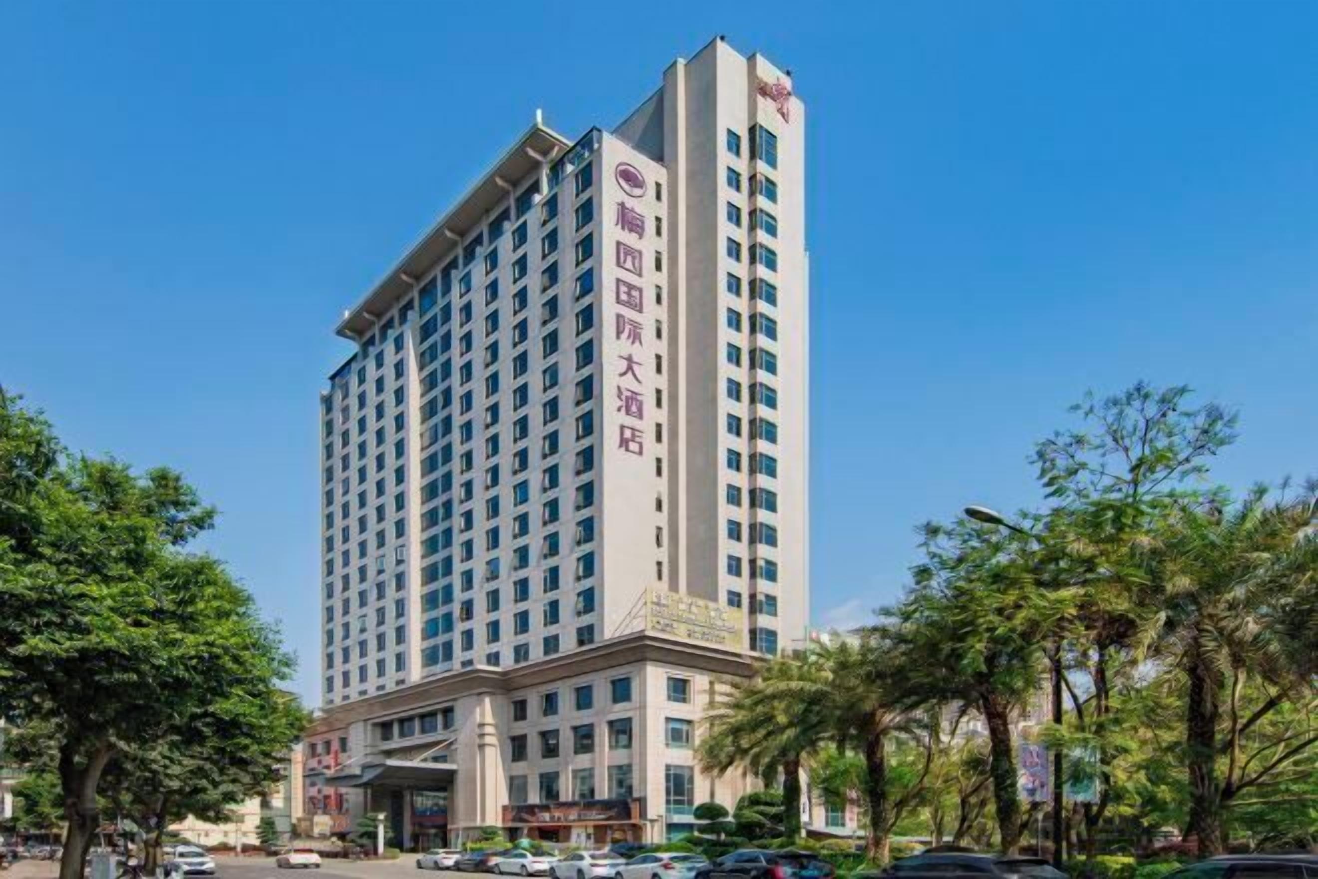 Ein hohes Hotel mit modernem Design, das eine markante Eingangshalle und mehrere Etagen aufweist.