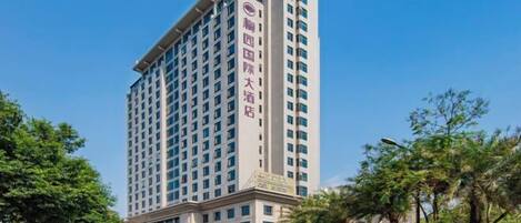 A tall hotel with a modern design, featuring a prominent entrance and multiple floors.